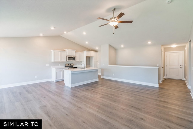 unfurnished living room with ceiling fan, sink, light hardwood / wood-style flooring, and vaulted ceiling