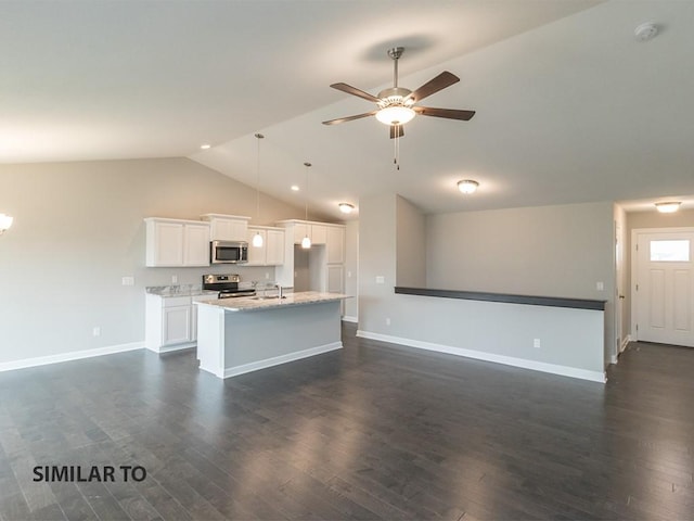 kitchen with white cabinets, dark hardwood / wood-style floors, appliances with stainless steel finishes, and vaulted ceiling