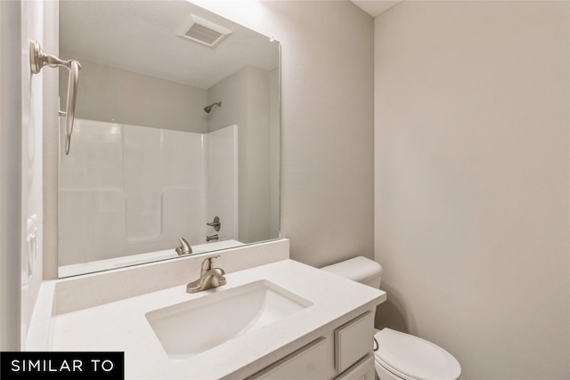 bathroom with vanity, toilet, and a shower