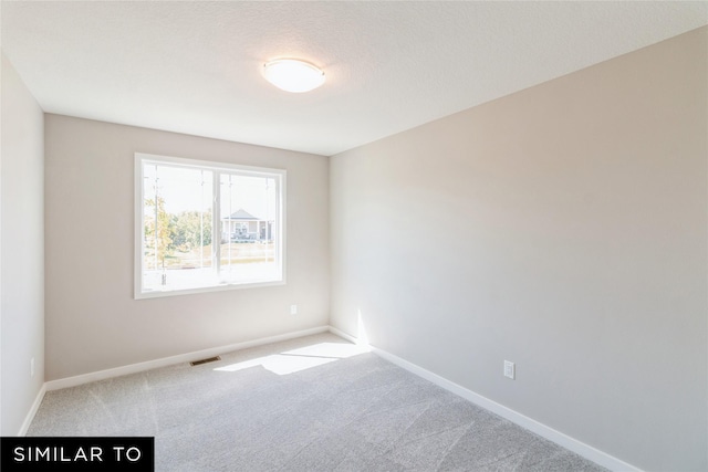 carpeted spare room featuring a textured ceiling