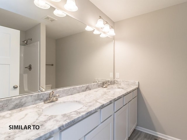 bathroom with walk in shower, vanity, wood-type flooring, and toilet