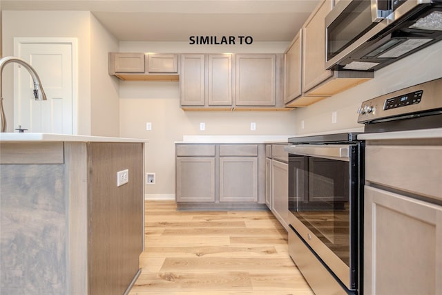 kitchen featuring sink, light hardwood / wood-style flooring, and appliances with stainless steel finishes