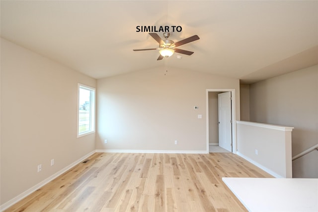 spare room featuring light wood-type flooring and vaulted ceiling