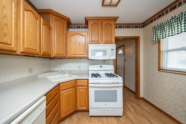 kitchen featuring light wood-type flooring, decorative backsplash, white appliances, and sink