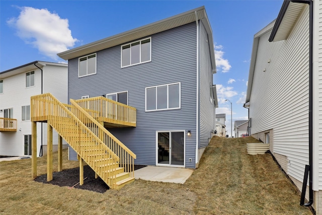 back of house with a lawn, a patio area, and a wooden deck