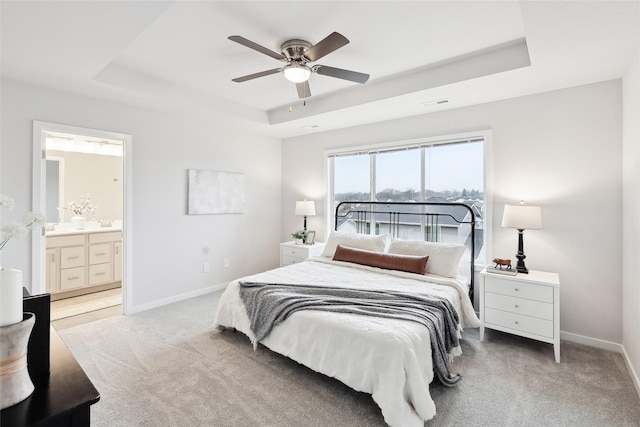 1745 Willow Ct, Norwalk, IA 50211 - carpeted bedroom featuring a tray ceiling, ensuite bath, and ceiling fan