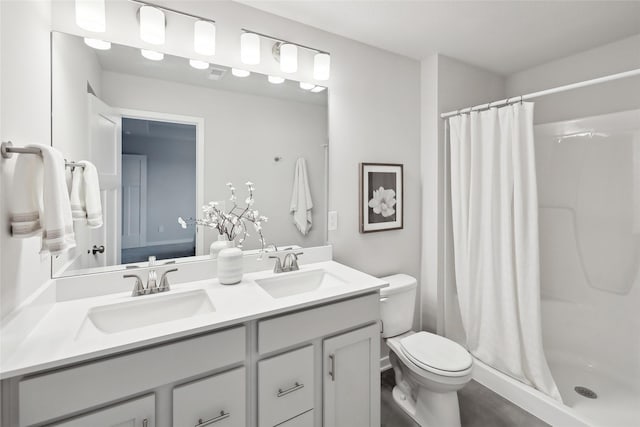 bathroom featuring a shower with shower curtain, vanity, and toilet