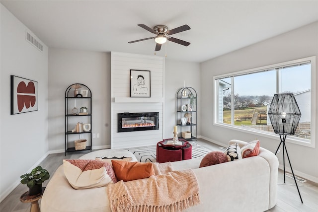 1727 Willow Ct, Norwalk, IA 50211 - living area featuring a ceiling fan, a fireplace, and wood finished floors