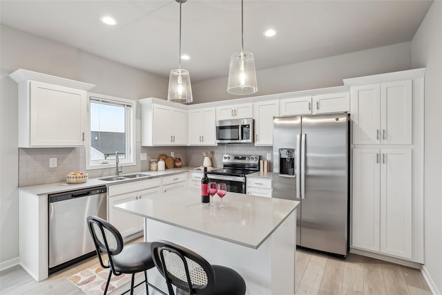 1727 Willow Ct, Norwalk, IA 50211 - kitchen featuring appliances with stainless steel finishes, white cabinetry, tasteful backsplash, light wood-style flooring, and light countertops