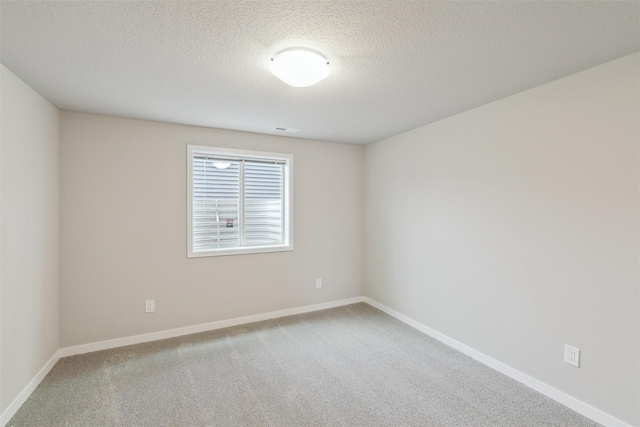 carpeted spare room featuring a textured ceiling