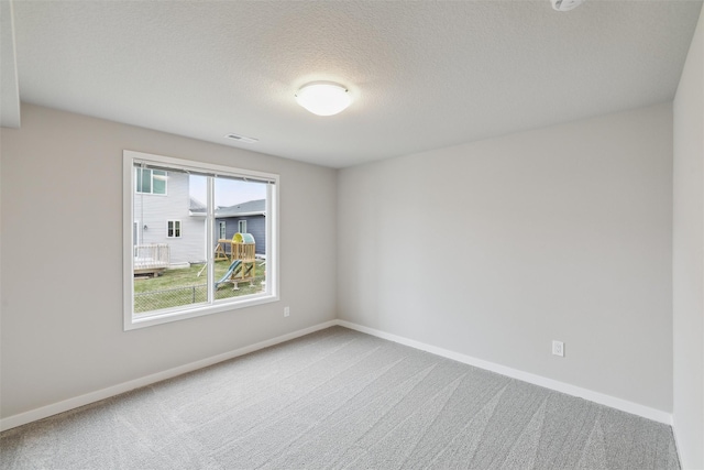 spare room with carpet floors and a textured ceiling