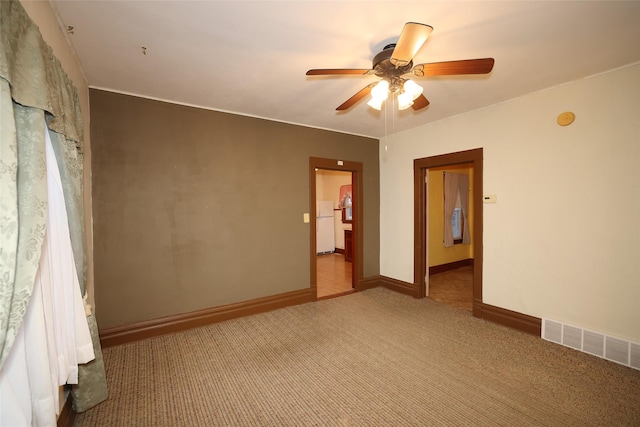 carpeted spare room with ceiling fan