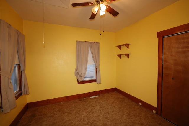 unfurnished bedroom featuring ceiling fan, a closet, and dark colored carpet