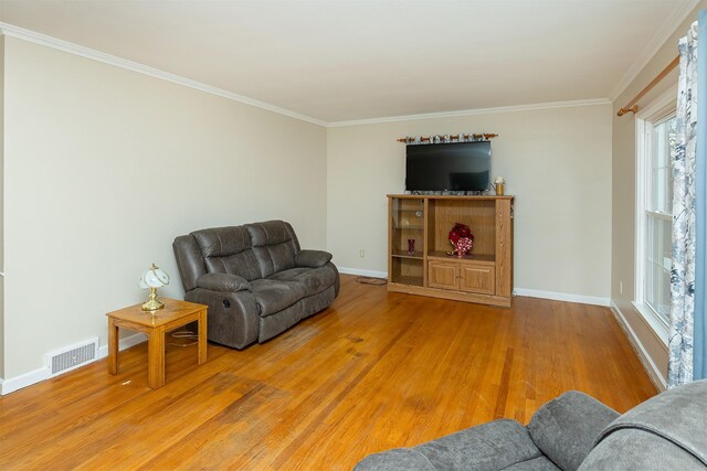 living room with wood-type flooring and ornamental molding