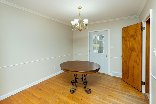 unfurnished dining area featuring an inviting chandelier, light hardwood / wood-style floors, and ornamental molding