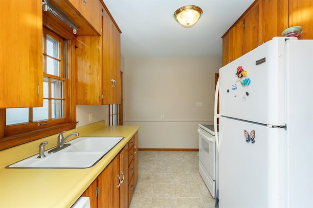 kitchen with sink, light tile patterned floors, and white appliances