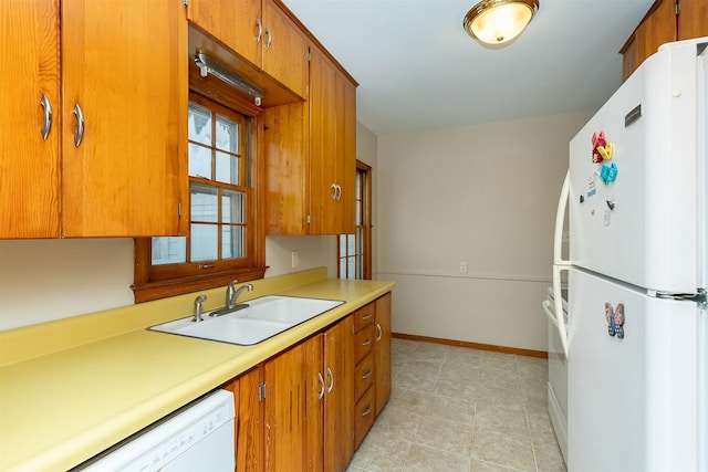 kitchen featuring light tile patterned flooring, white appliances, and sink