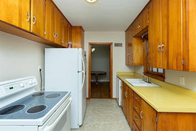 kitchen with light tile patterned flooring, white appliances, and sink