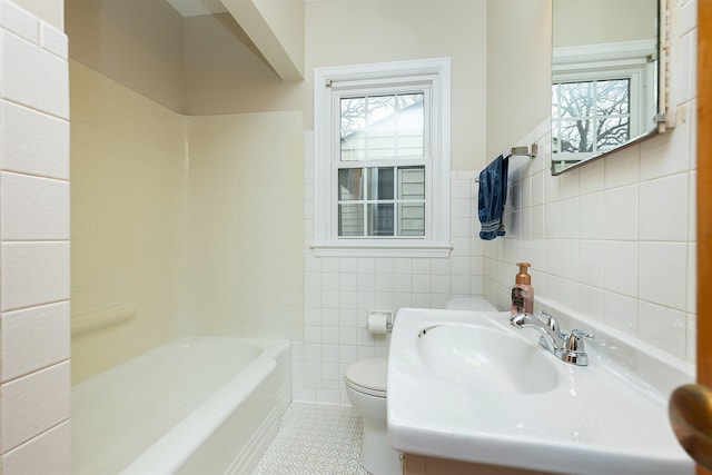 bathroom featuring tile patterned flooring, plenty of natural light, toilet, and tile walls