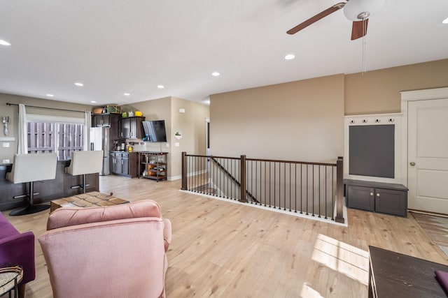 living room featuring ceiling fan and light hardwood / wood-style floors