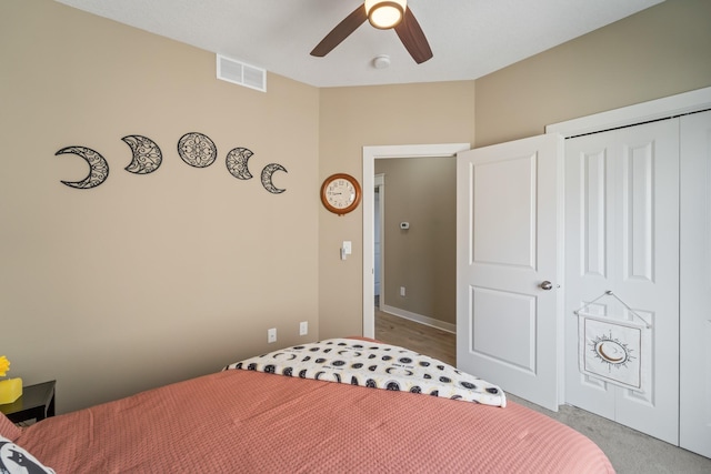 bedroom featuring ceiling fan, light carpet, and a closet