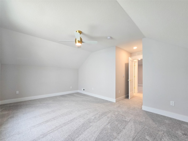 additional living space featuring light carpet, vaulted ceiling, and ceiling fan