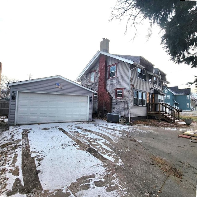 view of front of property featuring a garage and central AC unit