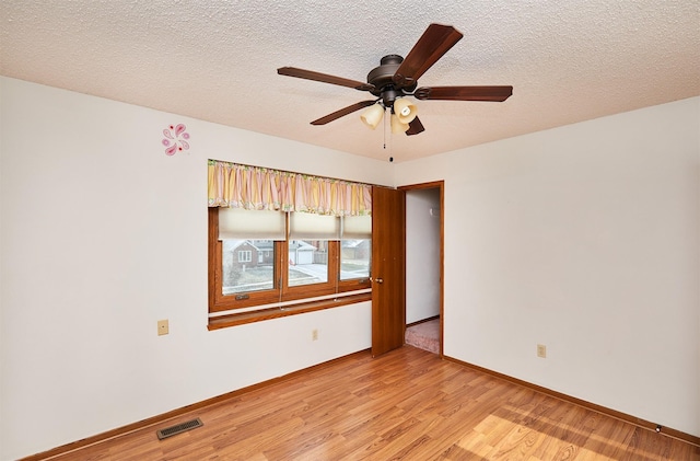 unfurnished room with ceiling fan, light hardwood / wood-style flooring, and a textured ceiling