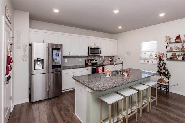 kitchen featuring a center island with sink, sink, dark hardwood / wood-style flooring, white cabinetry, and stainless steel appliances