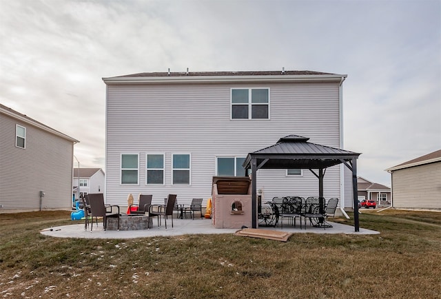 rear view of house with a gazebo, a patio area, a yard, and an outdoor fire pit