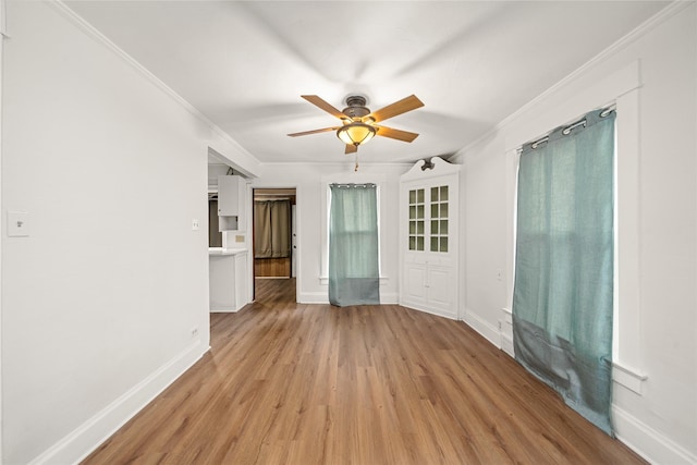 unfurnished room featuring light wood-type flooring, ceiling fan, and ornamental molding