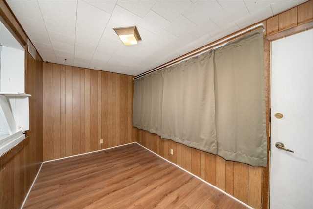 interior space with wood-type flooring and wooden walls