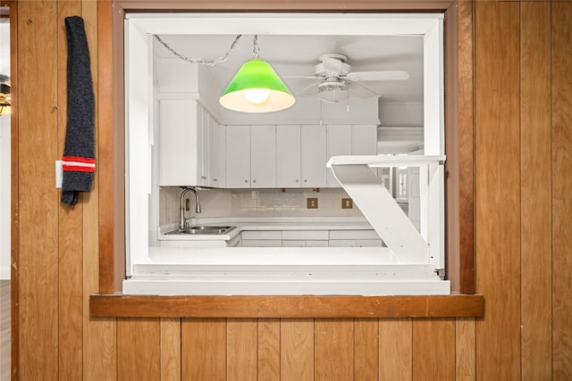 kitchen featuring pendant lighting, decorative backsplash, ceiling fan, and sink