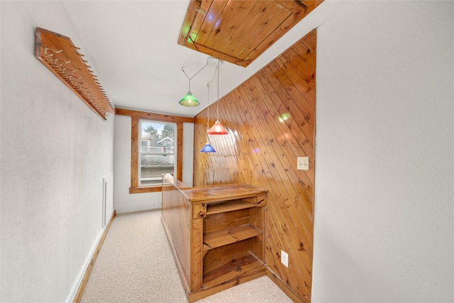 corridor with wood walls and light colored carpet