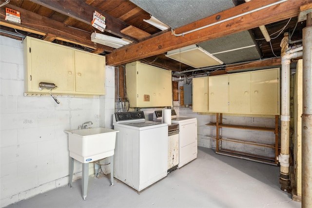 basement featuring separate washer and dryer, sink, and electric panel