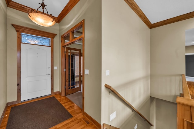 entrance foyer featuring hardwood / wood-style flooring and crown molding