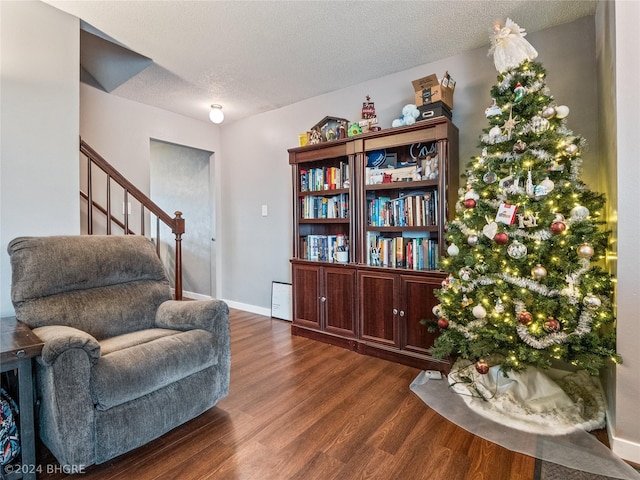 living area with dark wood-type flooring and a textured ceiling