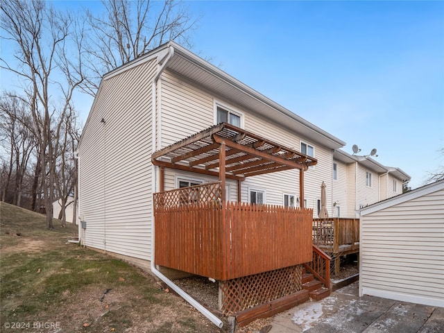 view of side of property featuring a pergola and a wooden deck