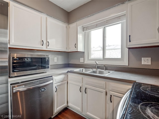 kitchen featuring dark hardwood / wood-style flooring, white cabinetry, sink, and appliances with stainless steel finishes