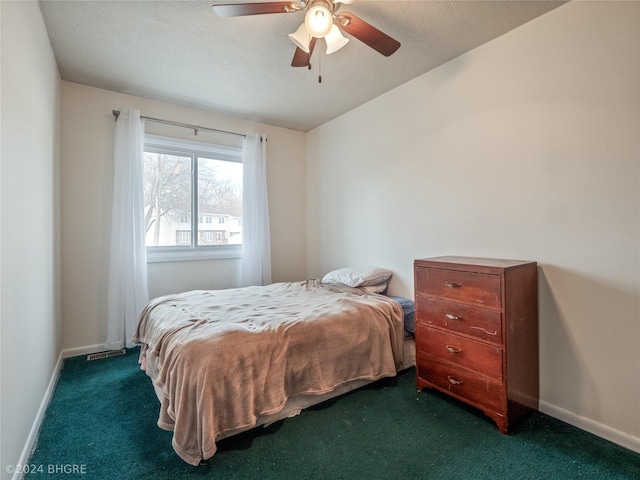 bedroom featuring ceiling fan and dark carpet