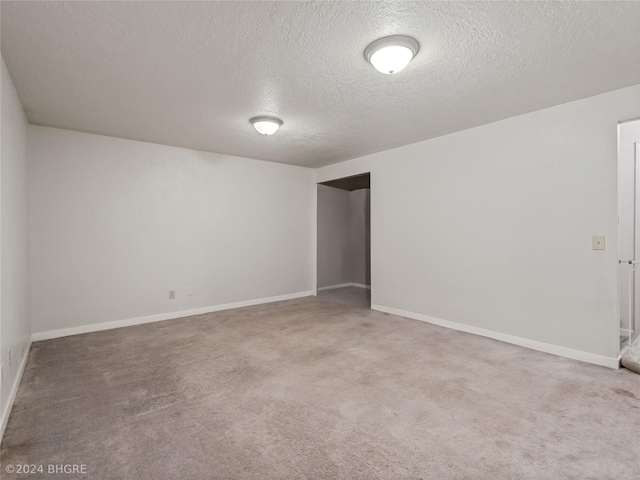 carpeted spare room featuring a textured ceiling