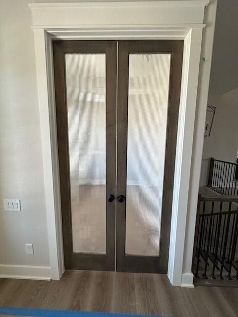 doorway with french doors, baseboards, and dark wood-style flooring