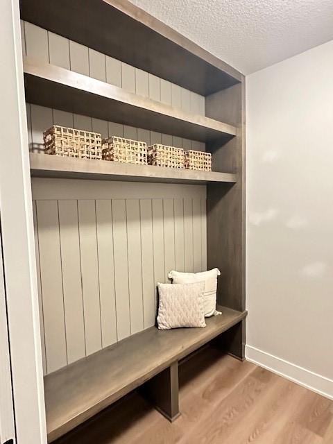 703 Richland Ct, Van Meter, IA 50261 - mudroom featuring a textured ceiling, wood finished floors, and baseboards