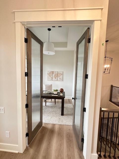 703 Richland Ct, Van Meter, IA 50261 - hall with a chandelier, wood finished floors, french doors, and baseboards