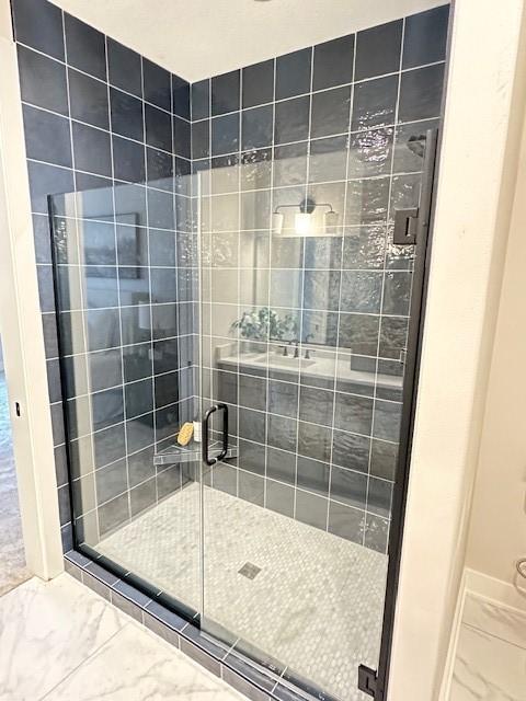 703 Richland Ct, Van Meter, IA 50261 - bathroom with marble finish floor, a shower stall, and baseboards