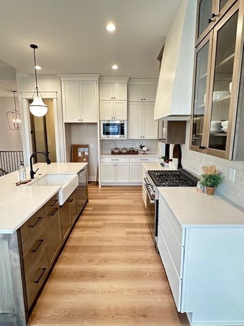 703 Richland Ct, Van Meter, IA 50261 - kitchen featuring a sink, white cabinets, appliances with stainless steel finishes, and light wood-style floors