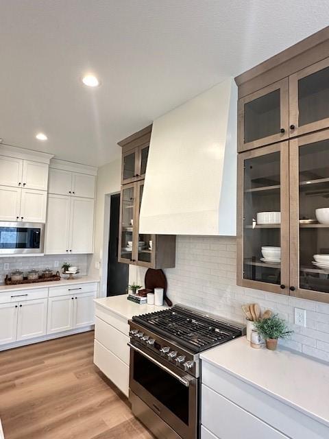 703 Richland Ct, Van Meter, IA 50261 - kitchen featuring white cabinetry, backsplash, appliances with stainless steel finishes, and light countertops