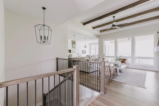 703 Richland Ct, Van Meter, IA 50261 - hall with beam ceiling, light wood-type flooring, an upstairs landing, and a chandelier