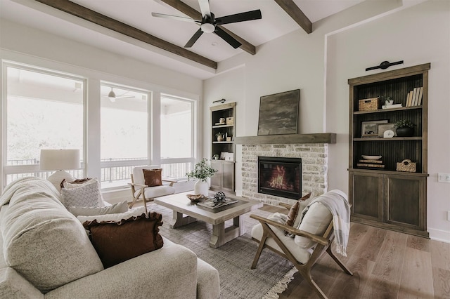 703 Richland Ct, Van Meter, IA 50261 - living room with a ceiling fan, beam ceiling, wood finished floors, a stone fireplace, and built in features