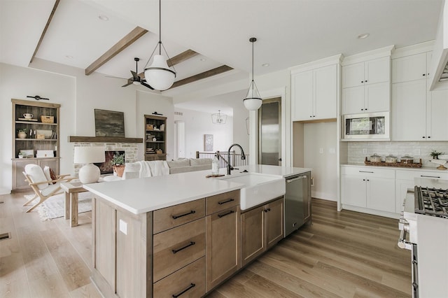 703 Richland Ct, Van Meter, IA 50261 - kitchen featuring appliances with stainless steel finishes, open floor plan, white cabinetry, light countertops, and backsplash